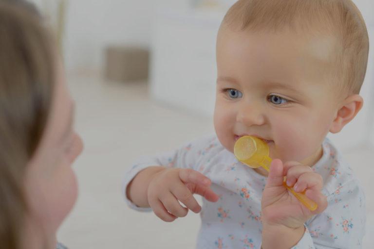 Maman qui donne une cuillère à son bébé