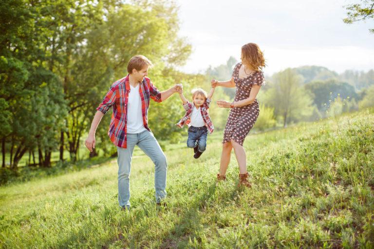 parents qui jouent avec leur enfant dans la forêt
