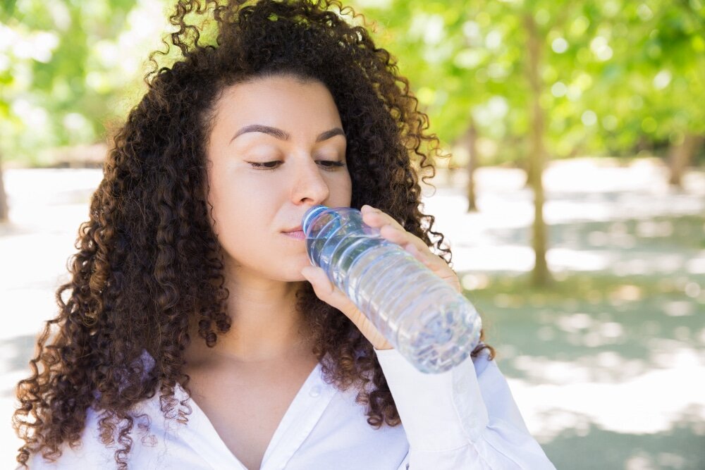 Femme dehors qui boit de l'eau